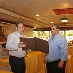 Alex Gutiérrez, ejecutivo de New Holland, lee el mensaje de la placa de reconocimiento.